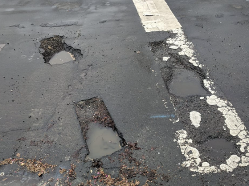 photo of deep street potholes