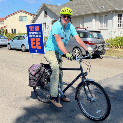 Man on bike with Yes on EE sign displayed in back